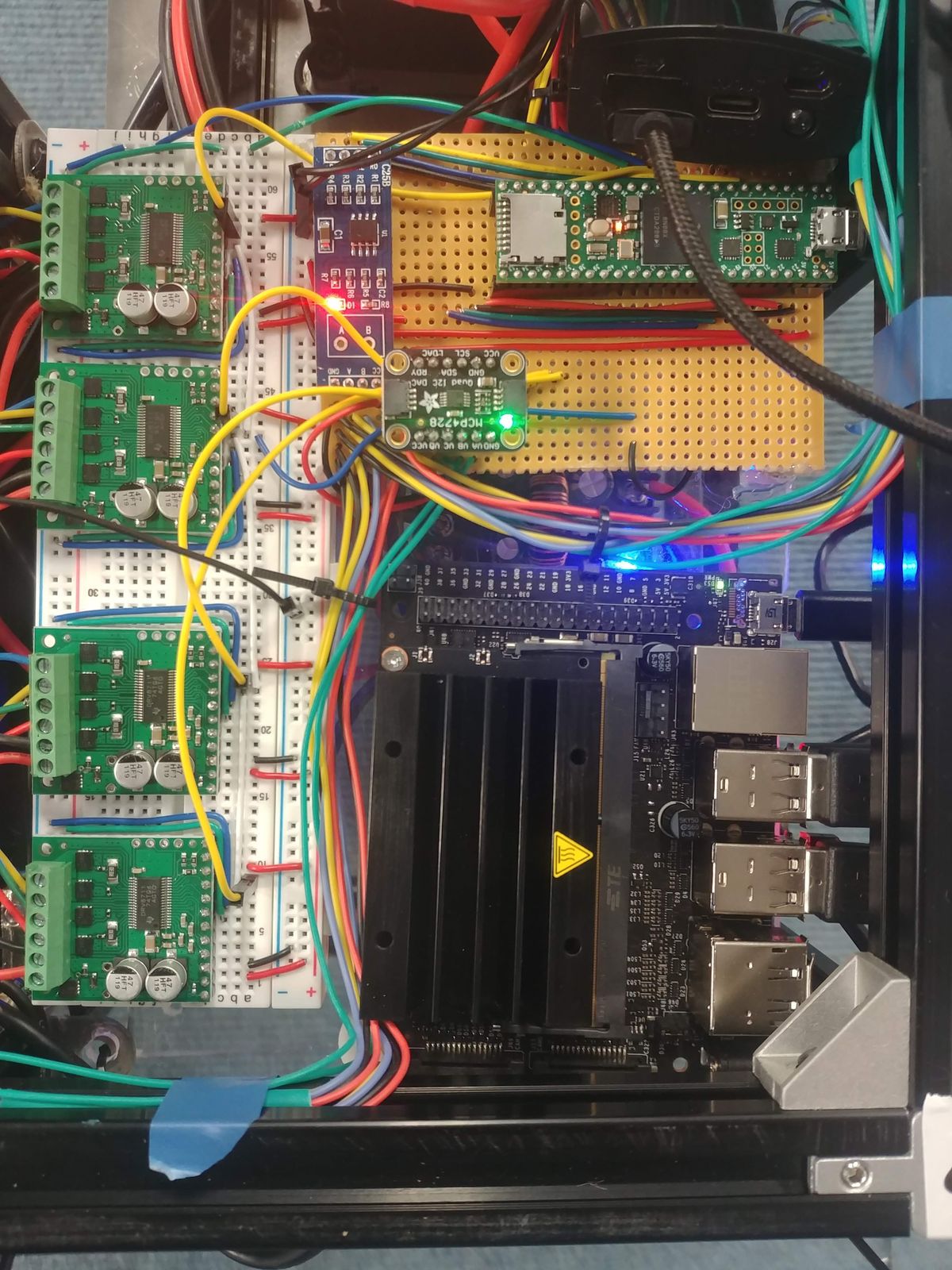 Breadboards, controller boards, and an NVIDIA Jetson Nano wired together during development